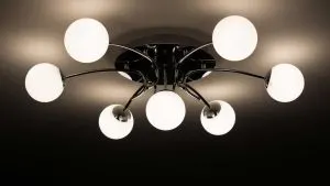 Modern chrome ceiling light fixture with seven glowing globe bulbs