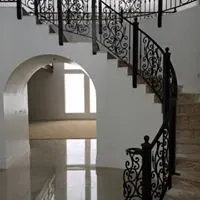 Elegant home entryway with a curved wrought-iron staircase railing