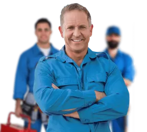 Confident electrician in blue uniform with two coworkers behind him