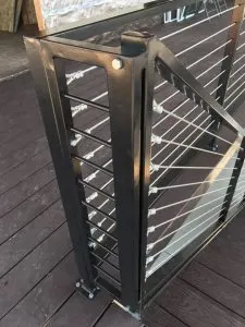 Modern metal cable railing gate on a wood deck