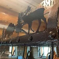 Close-up of metal pot rack with elk and wildlife silhouette designs