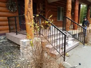 Log cabin with new deck, stairs, and black metal railings