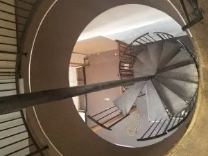Overhead view of a black spiral staircase with metal treads under construction