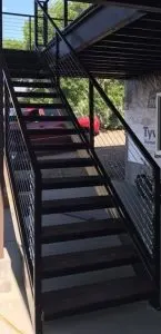 Black steel exterior staircase with open metal-grate treads