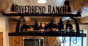 Riverbend Ranch metal pot rack with wildlife and pine tree silhouettes above a kitchen