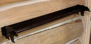 Custom wrought iron handrail bracket mounted on a pine log wall
