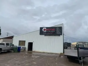 Exterior of the MANUFAB metal fabrication shop on an overcast day