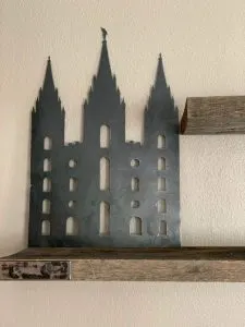 Metal wall art of the Salt Lake Temple silhouette on a wood shelf bracket