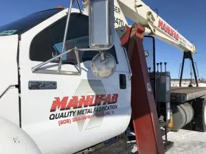 Ford F-750 boom truck with MANUFAB Quality Metal Fabrication logo, Rexburg ID