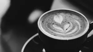Overhead view of a latte with heart-and-fern latte art, black and white